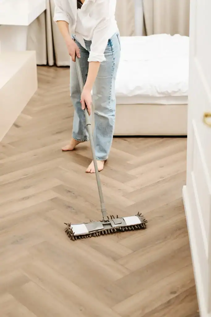 Flat mop cleaning a sealed hardwood floor with a diy castile soap formula that won't damage the wood finish