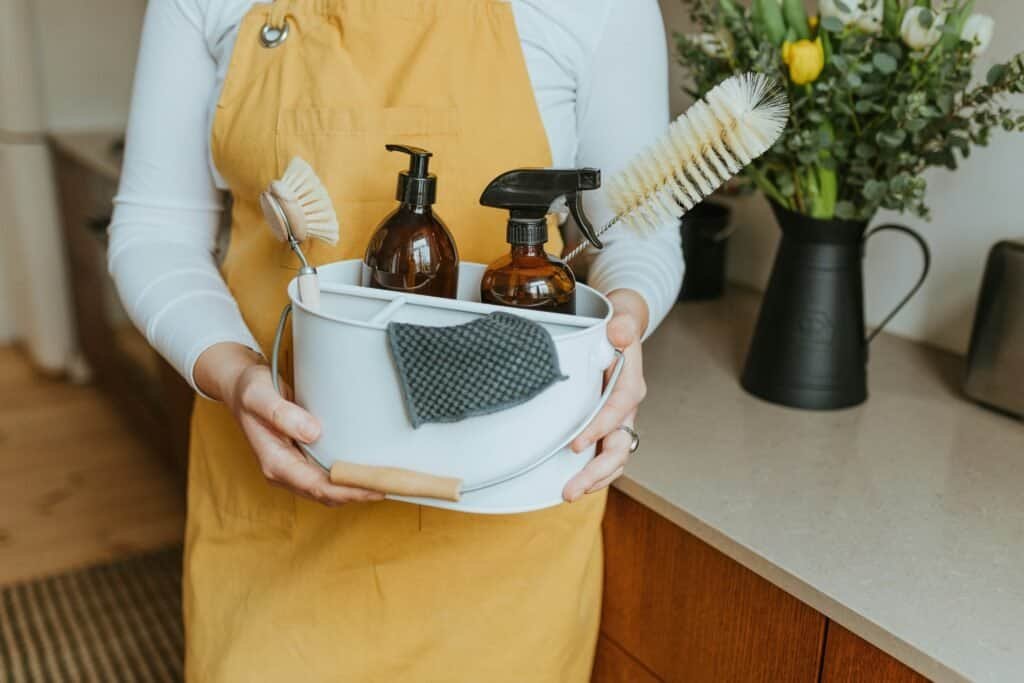 Eco-friendly homemade cleaning supplies with spray bottles and brushes.